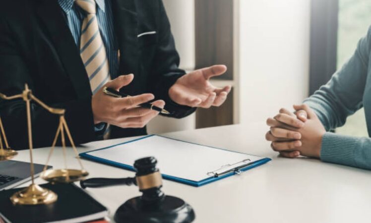 Deux professionnels se serrant la main sur des documents, évoquant la résolution réussie de "litiges professionnels" grâce à une médiation ou un accord