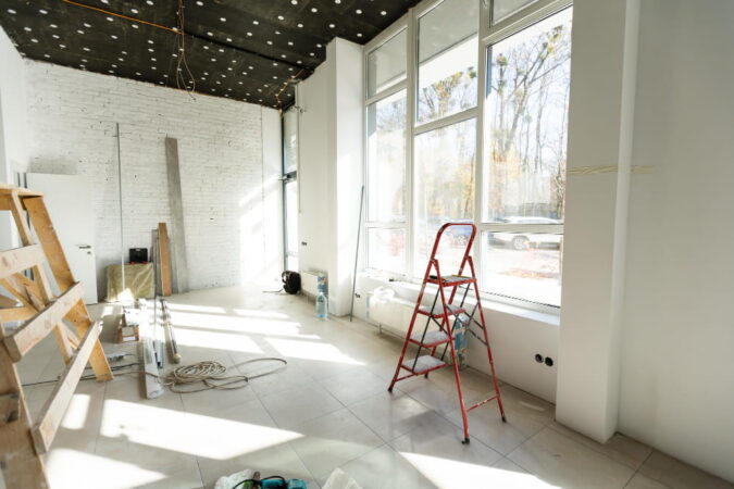 Intérieur en phase de démolition/construction d'un grand espace avec murs blancs et plafond noir