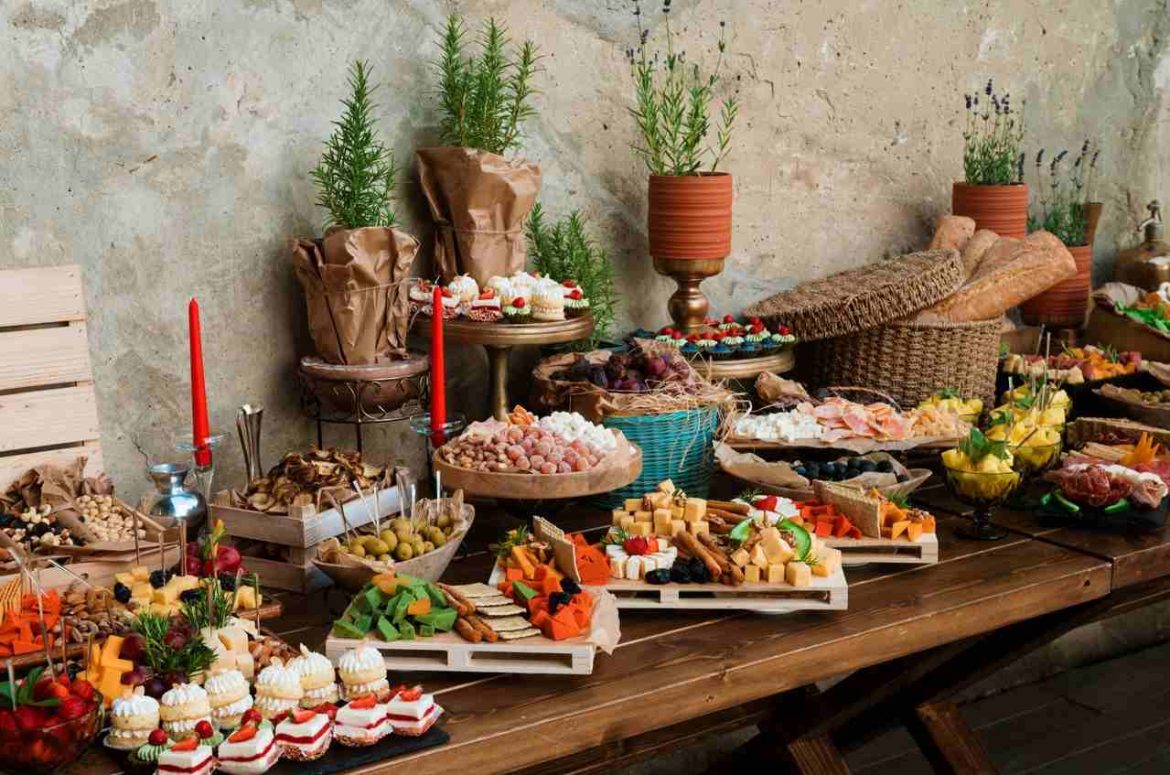 Table de banquet garnie d'amuse-bouches et de planchettes salées, parfaites comme idées de buffets froids faciles pour une fête de crémaillère.